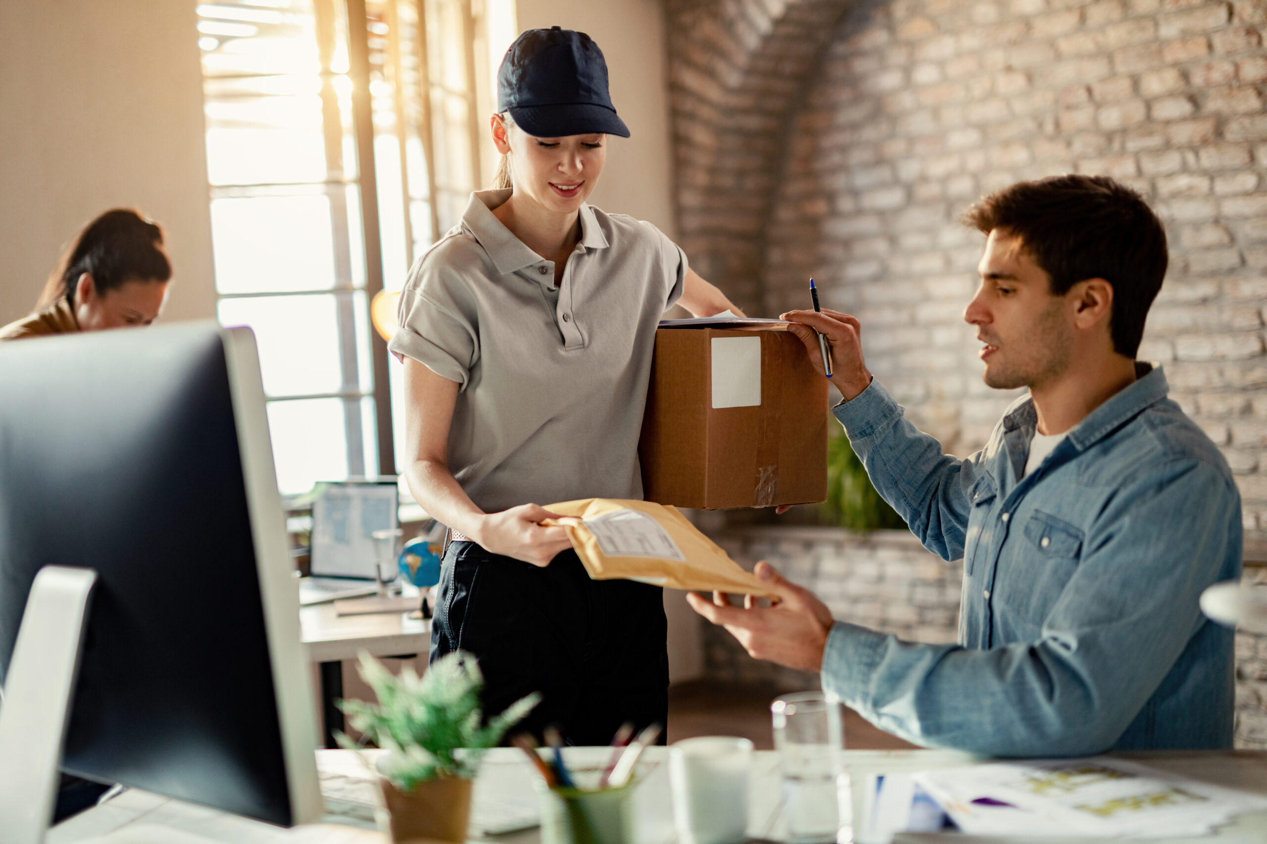 young delivery woman giving package to a businessman who is work